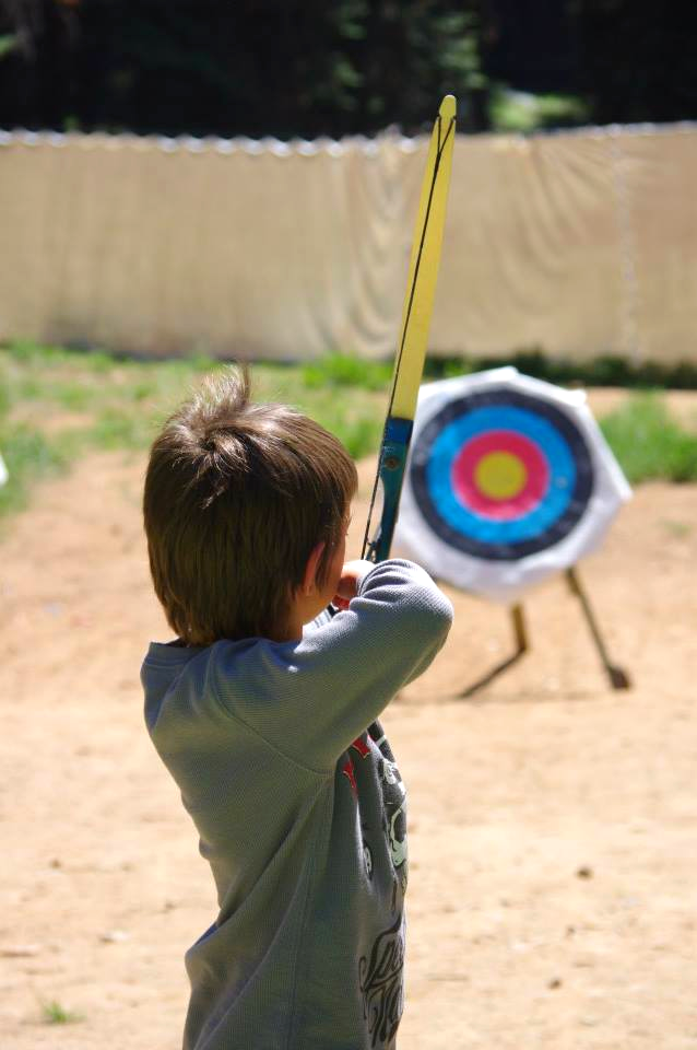 A kid shooting an arrow at a target