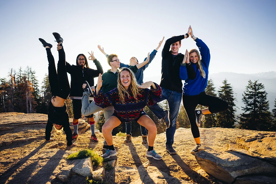 Guests and counselors doing yoga after a hike to Big Baldy